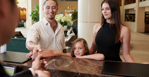 Gezin checkt in met paspoort bij een hotel